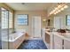 Bright bathroom featuring double sinks, a soaking tub, and a separate glass-enclosed shower at 4134 Riva De Tierra Ln, Las Vegas, NV 89135