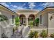 Charming front entrance with an ornate gate, arched entryway, and lush landscaping at 4134 Riva De Tierra Ln, Las Vegas, NV 89135