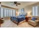 Comfortable bedroom with a ceiling fan, bay window with shutters, and tiled floor at 4134 Riva De Tierra Ln, Las Vegas, NV 89135