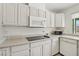 Well-lit kitchen with white cabinets, microwave, cooktop, and stainless-steel dishwasher at 4573 Plaza De Vista St, Las Vegas, NV 89120