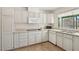 Well-lit kitchen features white cabinets, microwave, dishwasher and tile floor at 4573 Plaza De Vista St, Las Vegas, NV 89120