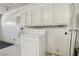 Laundry room featuring a washing machine and a dryer, with storage cabinets overhead at 4573 Plaza De Vista St, Las Vegas, NV 89120