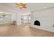Bright living room with painted fireplace, ceiling fan, and wood-look tile flooring at 4573 Plaza De Vista St, Las Vegas, NV 89120