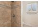 Tiled shower with decorative accent, alongside a window providing natural light in the bathroom at 4573 Plaza De Vista St, Las Vegas, NV 89120