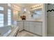 Luxurious bathroom with tub, tile floor, glass block window, and dual sinks at 4765 N Grand Canyon Dr, Las Vegas, NV 89129