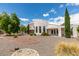 This home features a circular driveway, desert landscaping, and a modern stucco exterior at 4765 N Grand Canyon Dr, Las Vegas, NV 89129