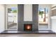 Modern fireplace with brick surround flanked by windows offering outdoor views at 5035 Meadow Grove Ct, Las Vegas, NV 89120