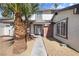 Close-up of the home's entrance featuring palm trees, white door and brick detail at 5035 Meadow Grove Ct, Las Vegas, NV 89120