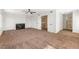 Spacious living room with plush carpet, fireplace, ceiling fan, staircase access, and bathroom at 5035 Meadow Grove Ct, Las Vegas, NV 89120