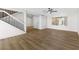 Open-concept living room with wood-look flooring, white walls, and a staircase at 5035 Meadow Grove Ct, Las Vegas, NV 89120