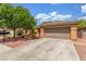 Single-story home featuring a well-maintained yard, mature tree, and a two-car garage at 5588 La Sendas Ct, Las Vegas, NV 89122