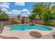 Backyard pool features rock waterfall, mature landscaping, and black metal safety fence at 5588 La Sendas Ct, Las Vegas, NV 89122