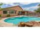 Backyard pool with rock features and desert landscaping is a cool retreat from the hot desert sun at 5588 La Sendas Ct, Las Vegas, NV 89122