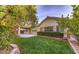 This backyard features a covered patio, well-maintained lawn, and mature landscaping that offers privacy and curb appeal at 5844 Gushing Spring Ave, Las Vegas, NV 89131