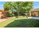Enjoy outdoor living in this backyard featuring a covered patio, lush lawn, and mature trees for shade at 5844 Gushing Spring Ave, Las Vegas, NV 89131