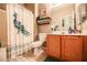 Well-lit bathroom featuring a shower with a peacock curtain and a wood cabinet at 5844 Gushing Spring Ave, Las Vegas, NV 89131