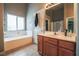 Bright bathroom with a soaking tub under a window and a wooden vanity at 5844 Gushing Spring Ave, Las Vegas, NV 89131