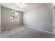 Spacious bedroom with neutral carpet, fan and a large window providing natural light at 5844 Gushing Spring Ave, Las Vegas, NV 89131