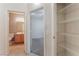 Hallway view showcasing a full bathroom, bedroom access, and a shelved closet at 5844 Gushing Spring Ave, Las Vegas, NV 89131