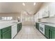 Eat-in kitchen with tile flooring, white and green cabinets, and backyard views at 5844 Gushing Spring Ave, Las Vegas, NV 89131