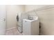 The well-lit laundry room has a washer, dryer, storage and tile flooring at 5844 Gushing Spring Ave, Las Vegas, NV 89131