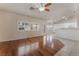 Open-concept living room with hardwood floors, ceiling fan, and bright natural light from windows at 5844 Gushing Spring Ave, Las Vegas, NV 89131