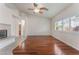 Bright living room featuring hardwood floors, fireplace, ceiling fan, and shuttered windows at 5844 Gushing Spring Ave, Las Vegas, NV 89131