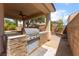 An outdoor kitchen features a built-in grill and stone accents at 5844 Gushing Spring Ave, Las Vegas, NV 89131