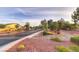 View of the neighborhood street with desert landscaping including river rock and cactus at 5844 Gushing Spring Ave, Las Vegas, NV 89131