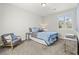 Comfortable bedroom with blue bedding, gray chair, and natural light from the window at 5852 Ireland Ridge Ct, Las Vegas, NV 89149