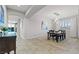 Airy dining room with modern chandelier, neutral paint, light tile flooring and view to the outdoor pool at 5852 Ireland Ridge Ct, Las Vegas, NV 89149