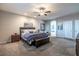 Large carpeted main bedroom featuring neutral paint and ceiling fan and view to main bathroom at 5852 Ireland Ridge Ct, Las Vegas, NV 89149