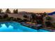 Backyard pool with fire feature, manicured landscaping, and mountain views at 5852 Ireland Ridge Ct, Las Vegas, NV 89149