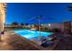 Inviting pool area featuring a shimmering pool, fire feature, in-pool seating and lush greenery, creating a tranquil oasis at 5852 Ireland Ridge Ct, Las Vegas, NV 89149