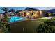 Stunning backyard featuring a sparkling pool, putting green, covered patio and lush landscaping, perfect for outdoor enjoyment at 5852 Ireland Ridge Ct, Las Vegas, NV 89149