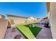 This backyard features artificial grass, pavers, and a low brick wall that offers privacy at 600 Suncrest Peak Pl, Henderson, NV 89011