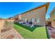 This backyard features artificial grass, pavers, and a low brick wall that offers privacy at 600 Suncrest Peak Pl, Henderson, NV 89011