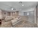Inviting bonus room features a large sofa, ceiling fan, and access to upper floor at 600 Suncrest Peak Pl, Henderson, NV 89011