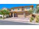 Charming exterior view of a two-story home with a large three-car garage and meticulously maintained landscaping at 600 Suncrest Peak Pl, Henderson, NV 89011