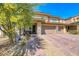 Beautiful two-story home featuring a brick driveway and lush landscaping, creating a welcoming curb appeal at 600 Suncrest Peak Pl, Henderson, NV 89011