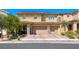 Street view of a two-story home featuring a three-car garage and low maintenance landscaping at 600 Suncrest Peak Pl, Henderson, NV 89011
