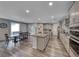 Open-concept kitchen with dining space and kitchen island and stainless appliances at 600 Suncrest Peak Pl, Henderson, NV 89011