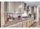 Kitchen close up of gray cabinets, granite counters, stainless vent hood and oven at 600 Suncrest Peak Pl, Henderson, NV 89011