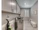 This laundry room features gray cabinets, a gray washer and dryer, and a window with shutters at 600 Suncrest Peak Pl, Henderson, NV 89011
