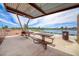 Picnic tables beneath a shaded structure with a lake and green space at 600 Suncrest Peak Pl, Henderson, NV 89011