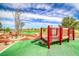 A colorful playground set against a background of lush landscaping, lakes, and beautiful clear skies at 600 Suncrest Peak Pl, Henderson, NV 89011