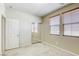 Bedroom with neutral carpet, sliding mirror closet doors, and two windows with blinds at 6255 W Arby Ave # 118, Las Vegas, NV 89118