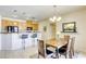 Open dining area features a wooden table set with modern chairs, adjacent to a kitchen with breakfast bar at 6255 W Arby Ave # 118, Las Vegas, NV 89118