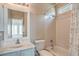 Bright bathroom featuring a single sink vanity, combination shower and tub with white tiling at 6329 Sterling Ranch Way, North Las Vegas, NV 89081