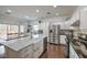 Bright kitchen featuring stainless steel appliances, white cabinets, marble countertops, and an island with a farmhouse sink at 6329 Sterling Ranch Way, North Las Vegas, NV 89081